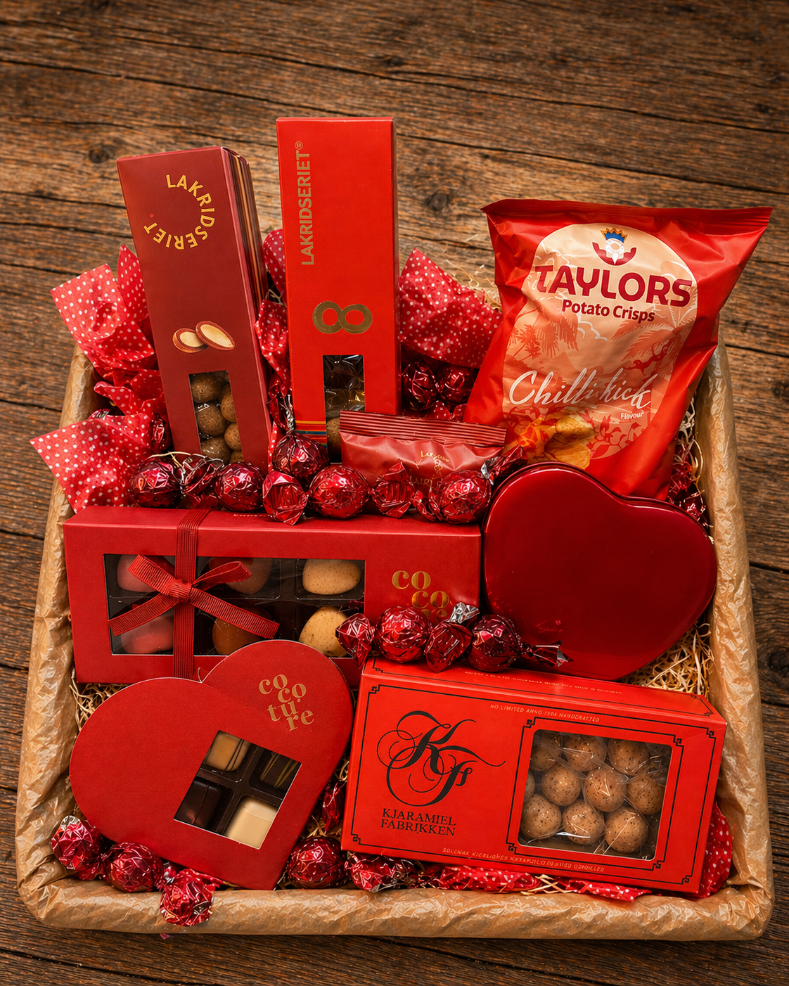 Rød luksus gavekurv med chokolade, lakrids, karameller og snacks, arrangeret som en kærlighedskurv med romantisk indpakning.