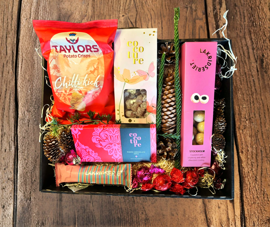 Gavekurv fyldt med chips, cocoture, lakridser, chokolade og fyldte chokoladekugler. 