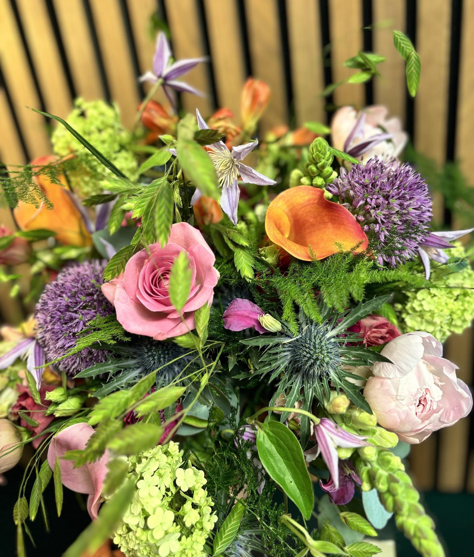 Vild og sprudlende buket bundet med farverige blomster.  