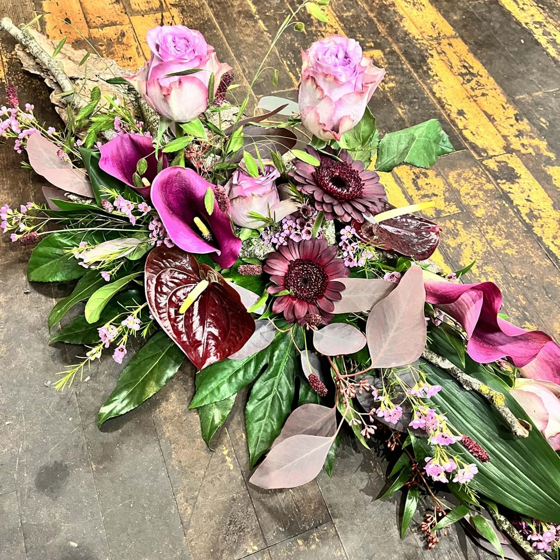 Båredekoration med blomster i lilla og lyserøde farver.