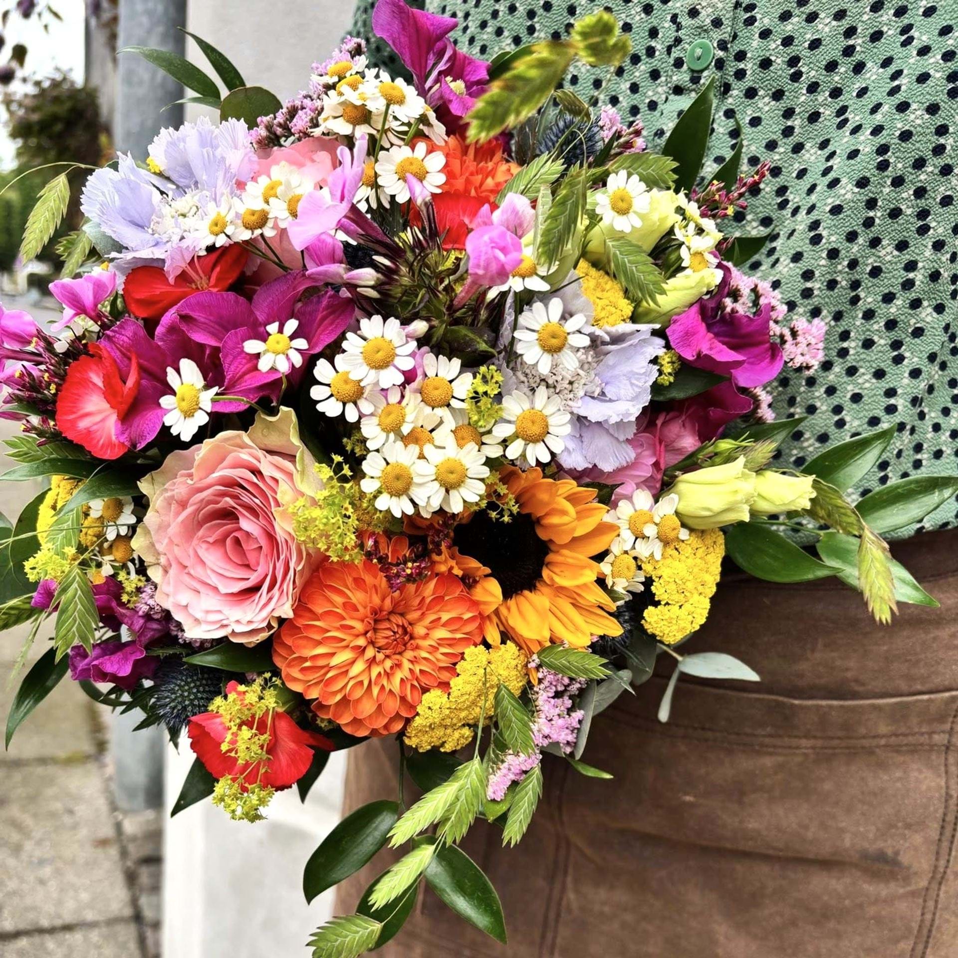 Sommerbuket med blomster i gule, lilla, lyserøde og orange nuancer.