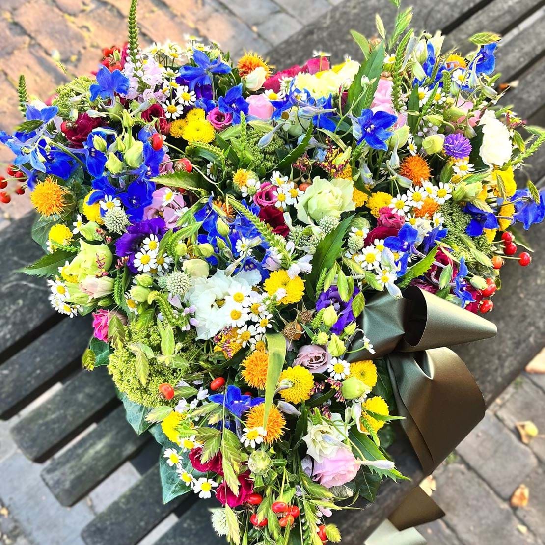 Hjerte med sprudlende blomsterflor i mixede farver.