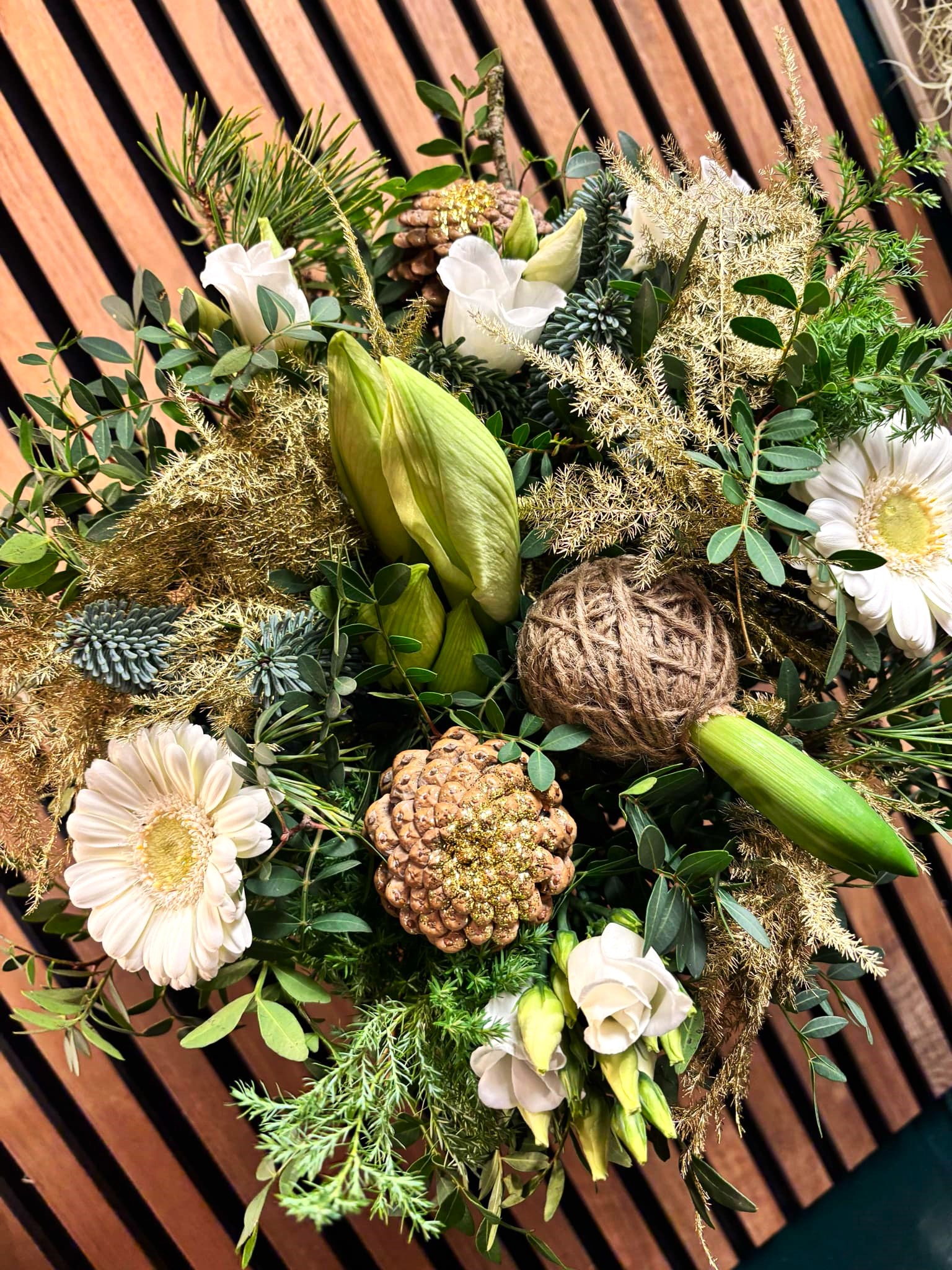 Tæt julebuket bundet med blomster i hvide og lysegrønne nuancer.