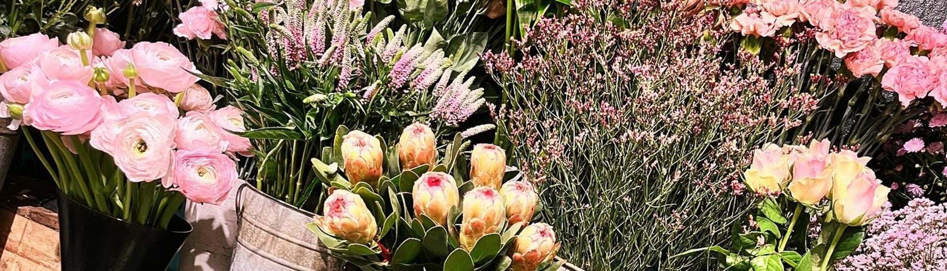 Podie med spande af alle mulige blomster i forskellige farver.